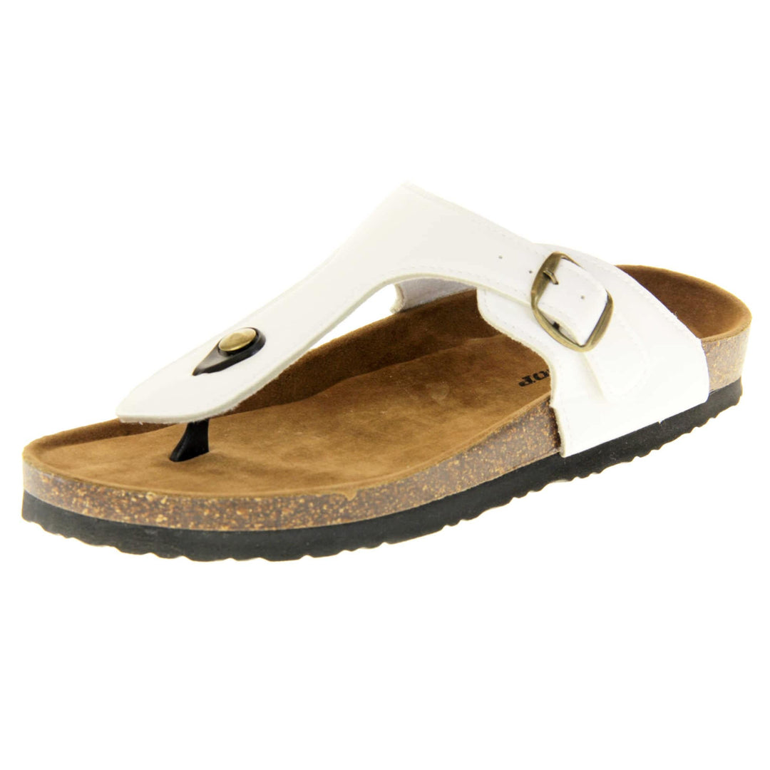White toe post sandals. White faux leather strap with toe post to the front and gold buckle to the outside. Soft tan faux suede footbed with cork effect outsole and black sole. Left foot at an angle.