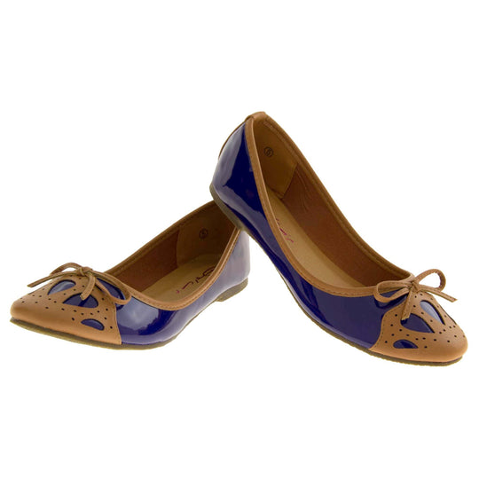 Women's ballet flats. Blue patent leather effect ballet pumps with brown faux leather collar and detailing to the toe. Brown sole with a very slight heel. Both feet in a V shape with the heel of the left foot leaning on top of the right heel.