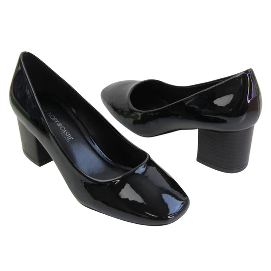 Womens black block heel. Womens court shoes with black patent faux leather uppers. Black block heel. Black faux leather lining with beige textile lining at the heel. Beige sole. Both feet at an angle facing top to tail.