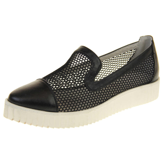 Womens flatforms. Loafer style shoes with a black net upper and black faux leather toe, heel and collar. White flat chunky platform. Cream insole. Left foot at an angle.