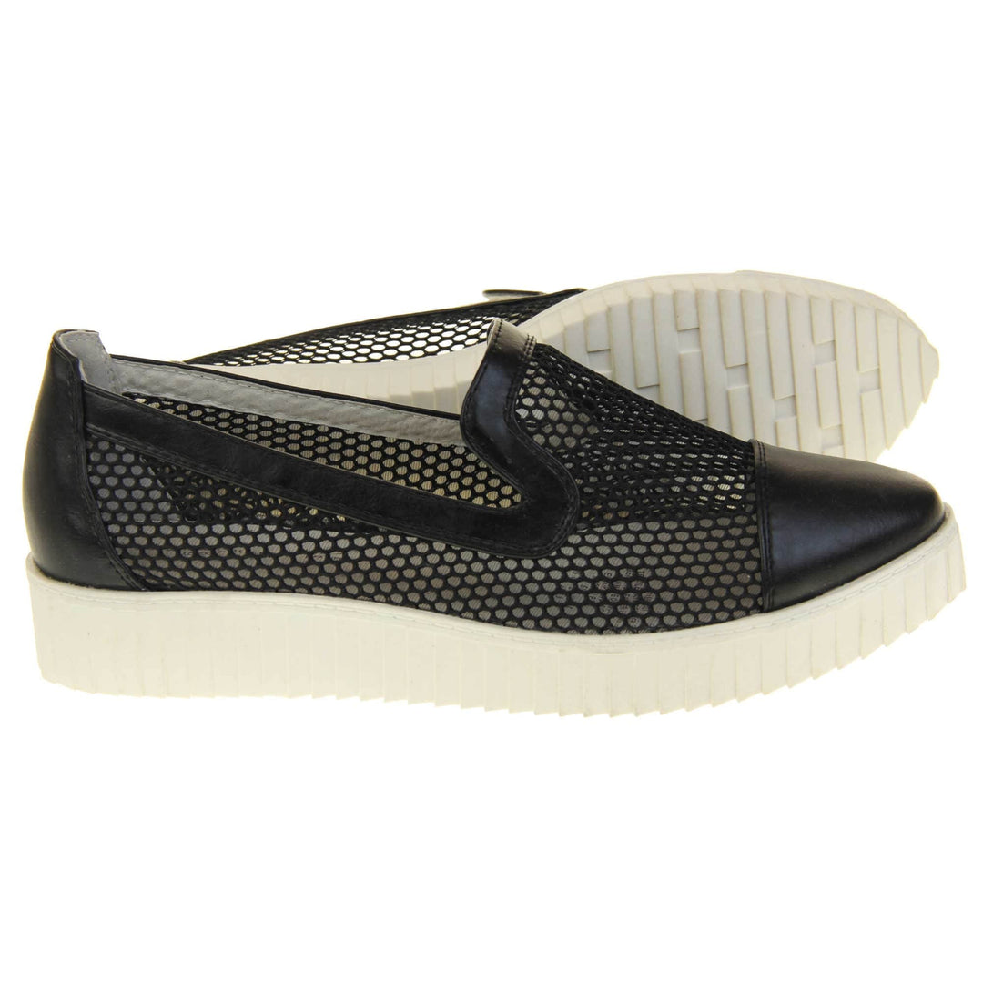 Womens flatforms. Loafer style shoes with a black net upper and black faux leather toe, heel and collar. White flat chunky platform. Cream insole. Both feet from a side profile with the left foot on its side behind the the right foot to show the sole.