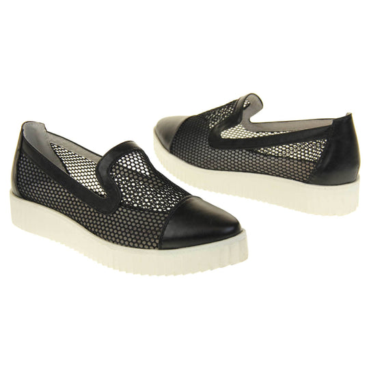 Womens flatforms. Loafer style shoes with a black net upper and black faux leather toe, heel and collar. White flat chunky platform. Cream insole. Both feet at an angle facing top to tail.
