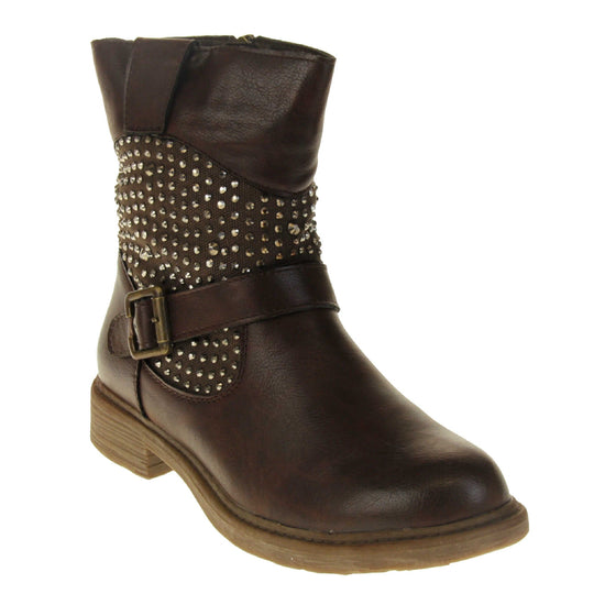 Womens leather biker boots. Biker style ankle boot with a brown faux leather upper. Textile panel running around the ankle with dark bronze diamante studs covering it. Single strap with buckle over the top of the ankle. Zip fastening down the inside of the boot. Brown sole with a slight heel. Right foot at an angle.
