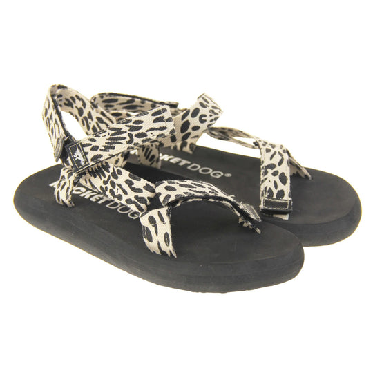 Womens adjustable sandals. Black foam platform outsole with cream canvas straps patterned with black dots to look similar to leopard print. Three adjustable touch fasten straps. Around the front and back of the ankle and one around the toes. Both feet at an angle.