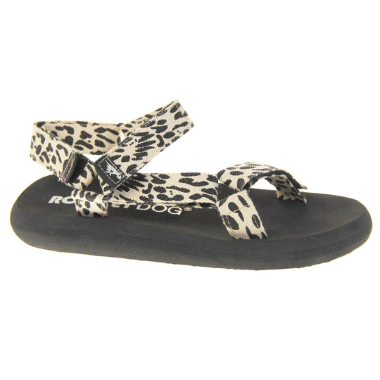 Womens adjustable sandals. Black foam platform outsole with cream canvas straps patterned with black dots to look similar to leopard print. Three adjustable touch fasten straps. Around the front and back of the ankle and one around the toes. Right foot at an angle. 