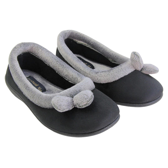 Womens ballerina slippers. Womens ballerina style slippers with black velour uppers. Grey, plush textile collar and two pom poms to the front of the shoe. Matching textile lining. Firm black sole. Both feet together at an angle.
