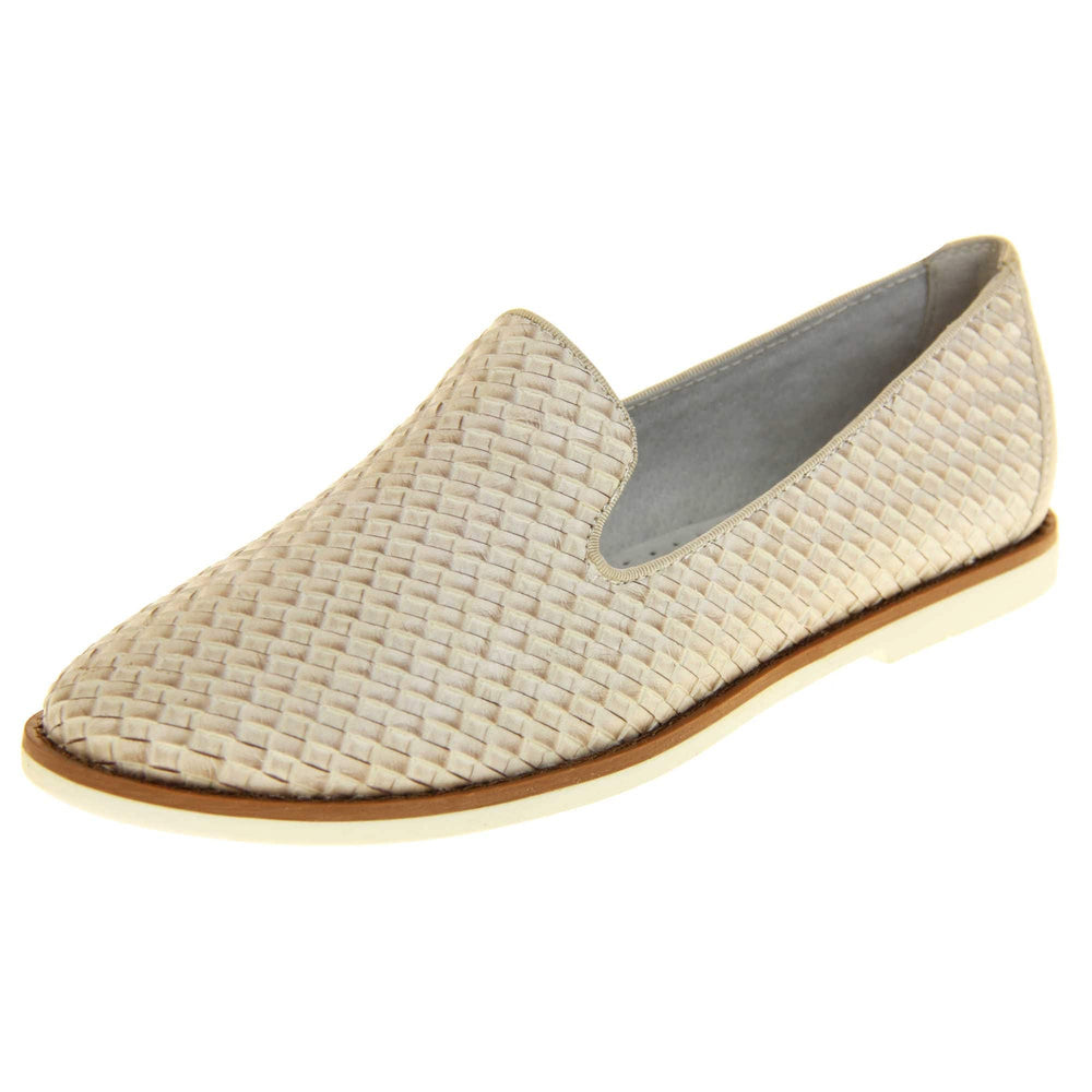 Womens beige loafers. Slip on loafer style shoe with a beige woven textile upper. Beige elasticated side gussets and plain beige textile around collar. White flat sole with brown line around the top and cream leather lining. Left foot at an angle.