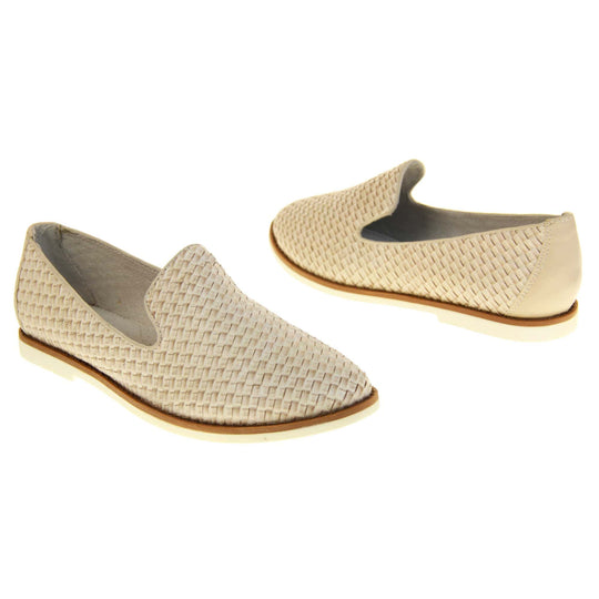 Womens beige loafers. Slip on loafer style shoe with a beige woven textile upper. Beige elasticated side gussets and plain beige textile around collar. White flat sole with brown line around the top and cream leather lining. Both feet at an angle facing top to tail.