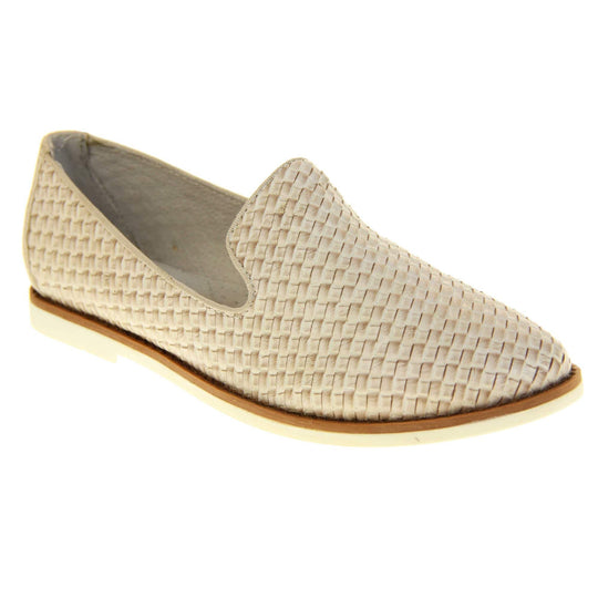 Womens beige loafers. Slip on loafer style shoe with a beige woven textile upper. Beige elasticated side gussets and plain beige textile around collar. White flat sole with brown line around the top and cream leather lining. Right foot at an angle.