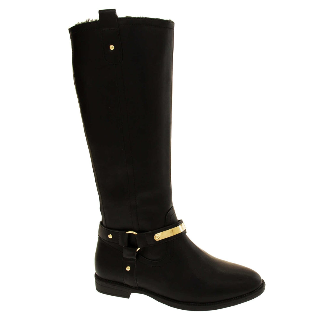 Womens black leather knee high boots. Knee high style boots with a black faux leather upper. A Tri strap going around the ankle and down to the bottom of the boot joined by the ankle with a good loop. Gold plate to the front of the ankle strap. Zip up the inside of the boot. Faux leather loop on the top of the outside of the boot to help with pulling it on. Right foot at an angle.