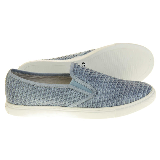 Womens blue loafers. Slip on loafer style shoe with a pale blue woven textile upper. Blue elasticated side gussets and plain blue textile around collar. White flat sole and cream leather lining. Both feet from a side profile with the left foot on its side behind the the right foot to show the sole.
