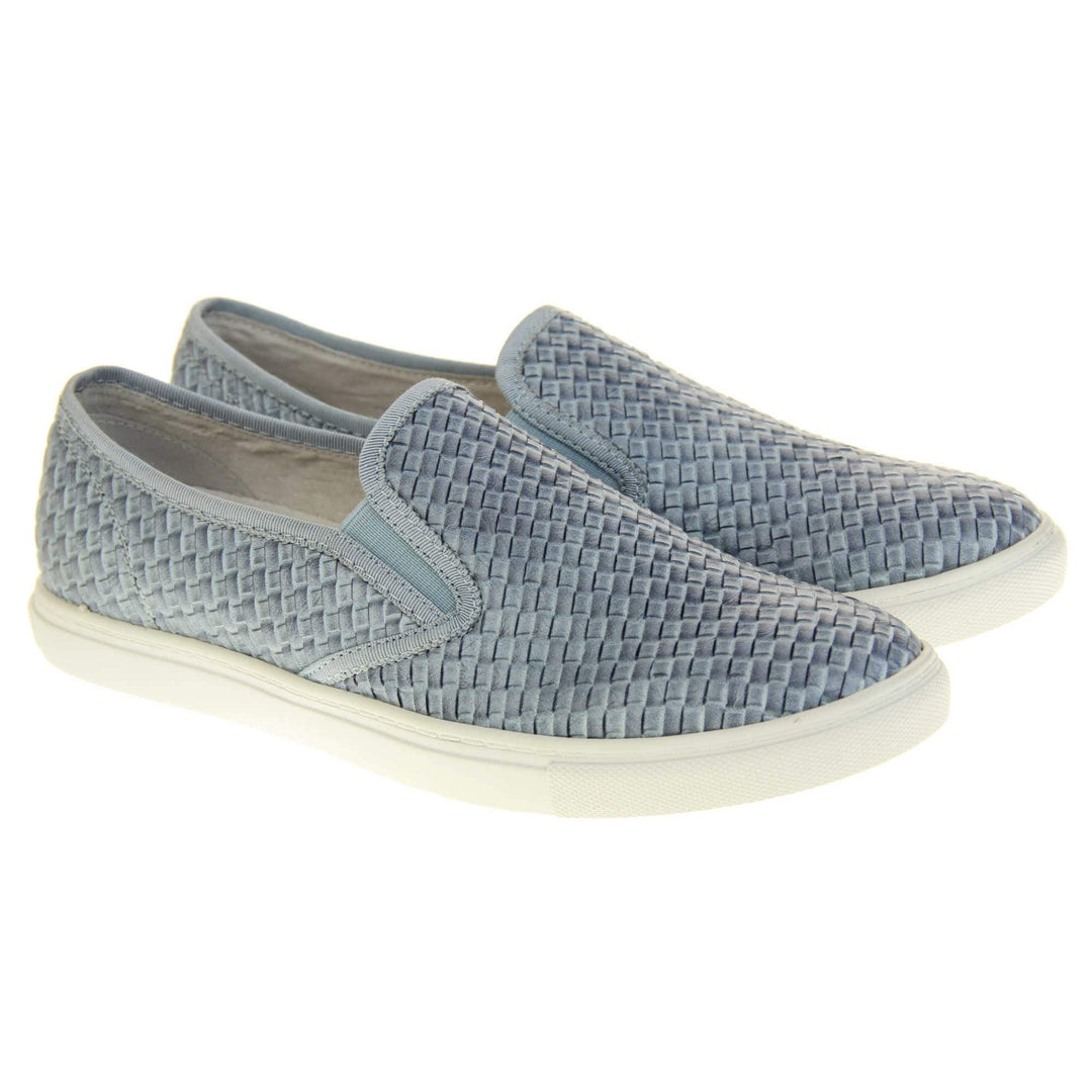Womens blue loafers. Slip on loafer style shoe with a pale blue woven textile upper. Blue elasticated side gussets and plain blue textile around collar. White flat sole and cream leather lining. Both feet together at a slight angle.