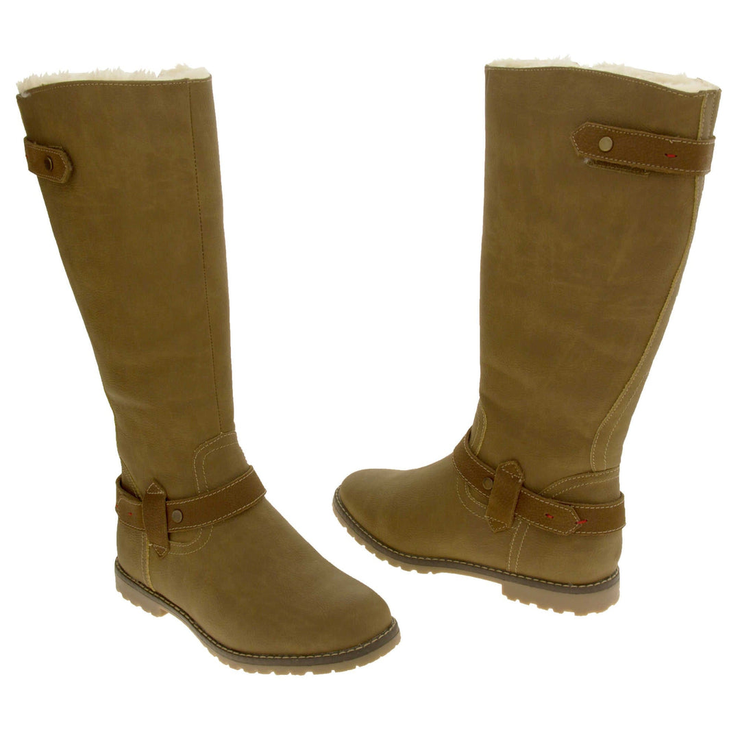 Womens brown tall boots. Almost knee high boots with a light brown faux suede upper. Brown faux leather strap around the ankle and the back half of the neck of the boot. Brown sole with chunky tread. Zip fastening down the inside of the leg. Both feet from a slight angle facing top to tail.