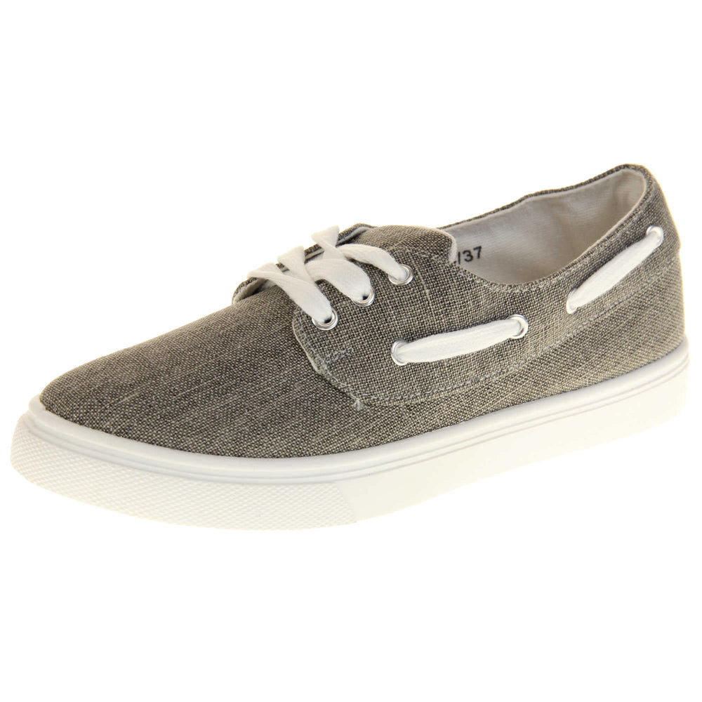 Womens canvas pumps. Sneaker style shoes with a grey canvas upper and white laces and white lace detailing around the outside of the collar. White outsole with slip-resistant grip to the bottom. Left foot at an angle.