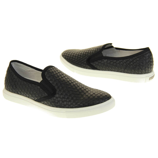 Womens casual loafers. Slip on loafer style shoe with a black woven textile upper. Black elasticated side gussets and plain black textile around collar. White flat sole and cream leather lining. Both feet at an angle facing top to tail.