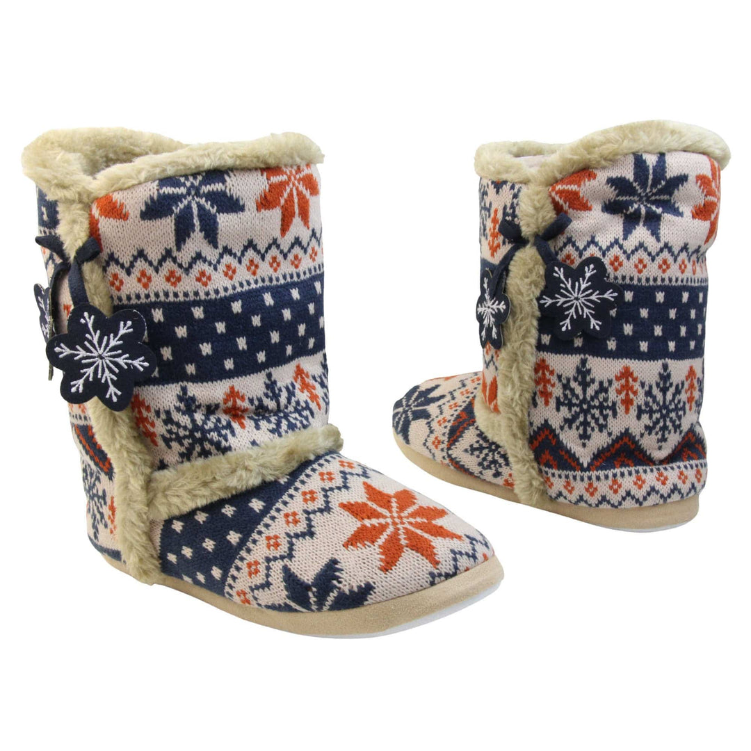 Womens Christmas Slipper Boots - Blue, beige and brown snowflake knitted upper with beige fur lining and trim. Navy blue and white snowflake shaped tassels to side. Both feet at angle facing top to tail.