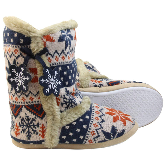 Womens Christmas Slipper Boots - Blue, beige and brown snowflake knitted upper with beige fur lining and trim. Navy blue and white snowflake shaped tassels to side. Both feet with white outsole showing.