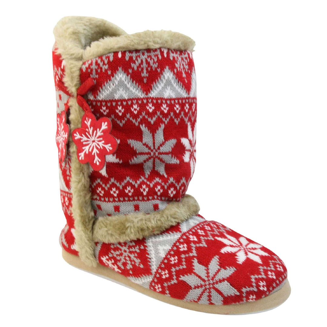 Womens Christmas Slippers - Red snowflake knitted upper with beige fur lining and trim. Two snowflake shaped tassels to the side. Right foot at angle.