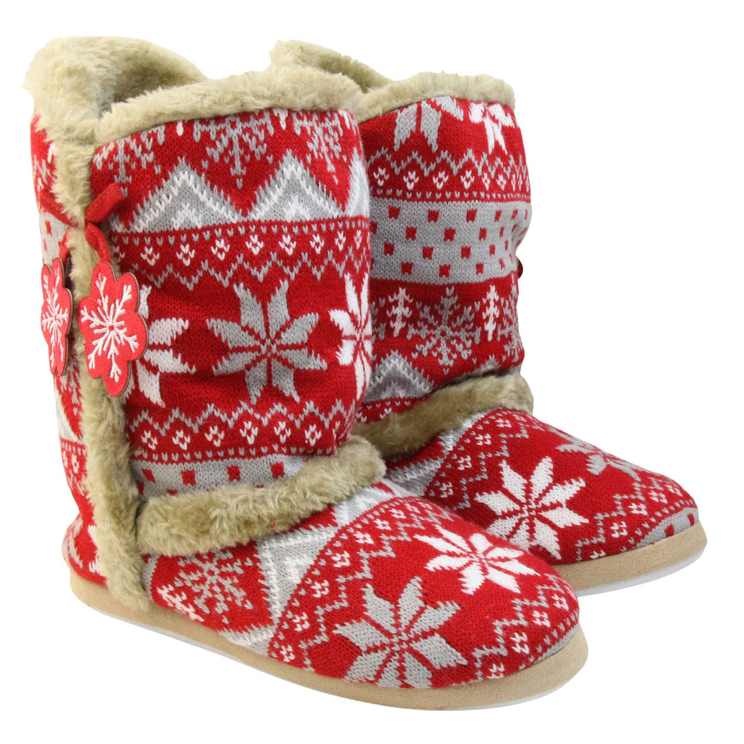 Womens Christmas Slippers - Red snowflake knitted upper with beige fur lining and trim. Two snowflake shaped tassels to the side. Both feet together at an angle.