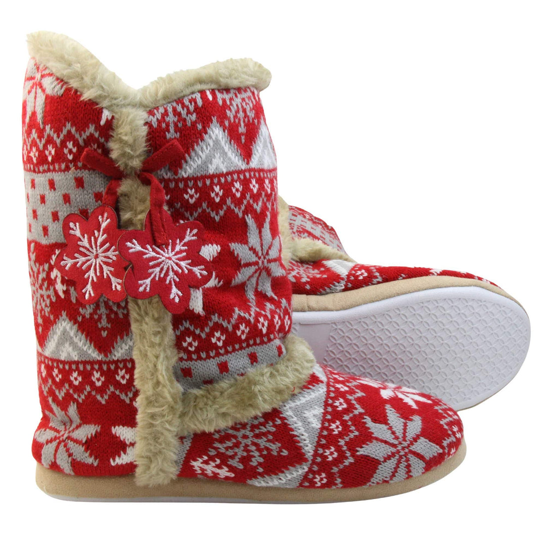Womens Christmas Slippers - Red snowflake knitted upper with beige fur lining and trim. Two snowflake shaped tassels to the side. Both feet with white outsole showing.