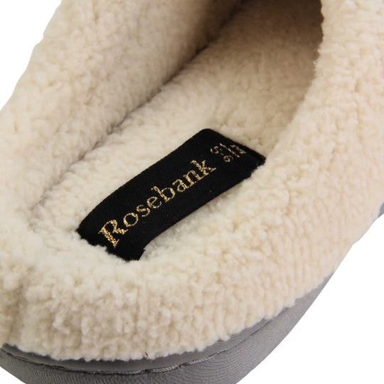 Womens cotton slippers. Womens slippers in a mule style. With grey cotton knit uppers and cream faux fur collar and lining. Grey hard synthetic soles with grip to the base. Close up of the back of the slipper to show the faux fur lining.