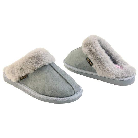 Womens faux fur mule slippers. Slip on style slippers with light grey faux suede uppers. Light grey faux fur lining and collar. Firm grey outsole with grip on the bottom. Both feet at an angle, facing top to tail.