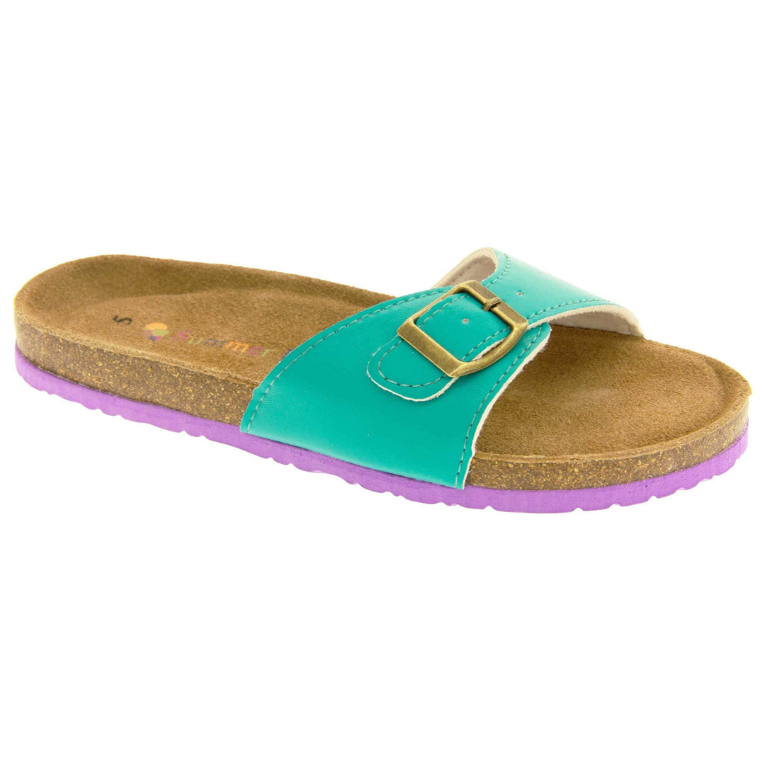 Womens green sliders. Green faux leather strap with gold buckle. Soft tan faux suede footbed with cork effect outsole and purple sole. Right foot at an angle.
