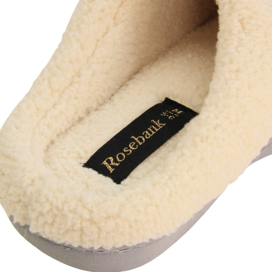 Womens hard sole slippers. Womens slippers in a mule style. With pink cotton knit uppers and cream faux fur collar and lining. Grey hard synthetic soles with grip to the base. Close up of the back of the slipper to show the faux fur lining.