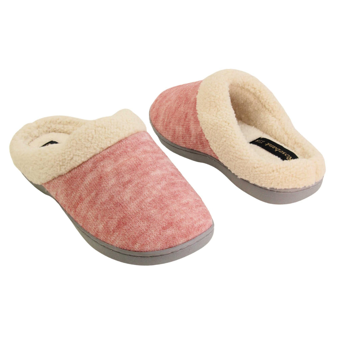 Womens hard sole slippers. Womens slippers in a mule style. With pink cotton knit uppers and cream faux fur collar and lining. Grey hard synthetic soles with grip to the base. Both shoes spaced apart, facing top to tail at an angle.