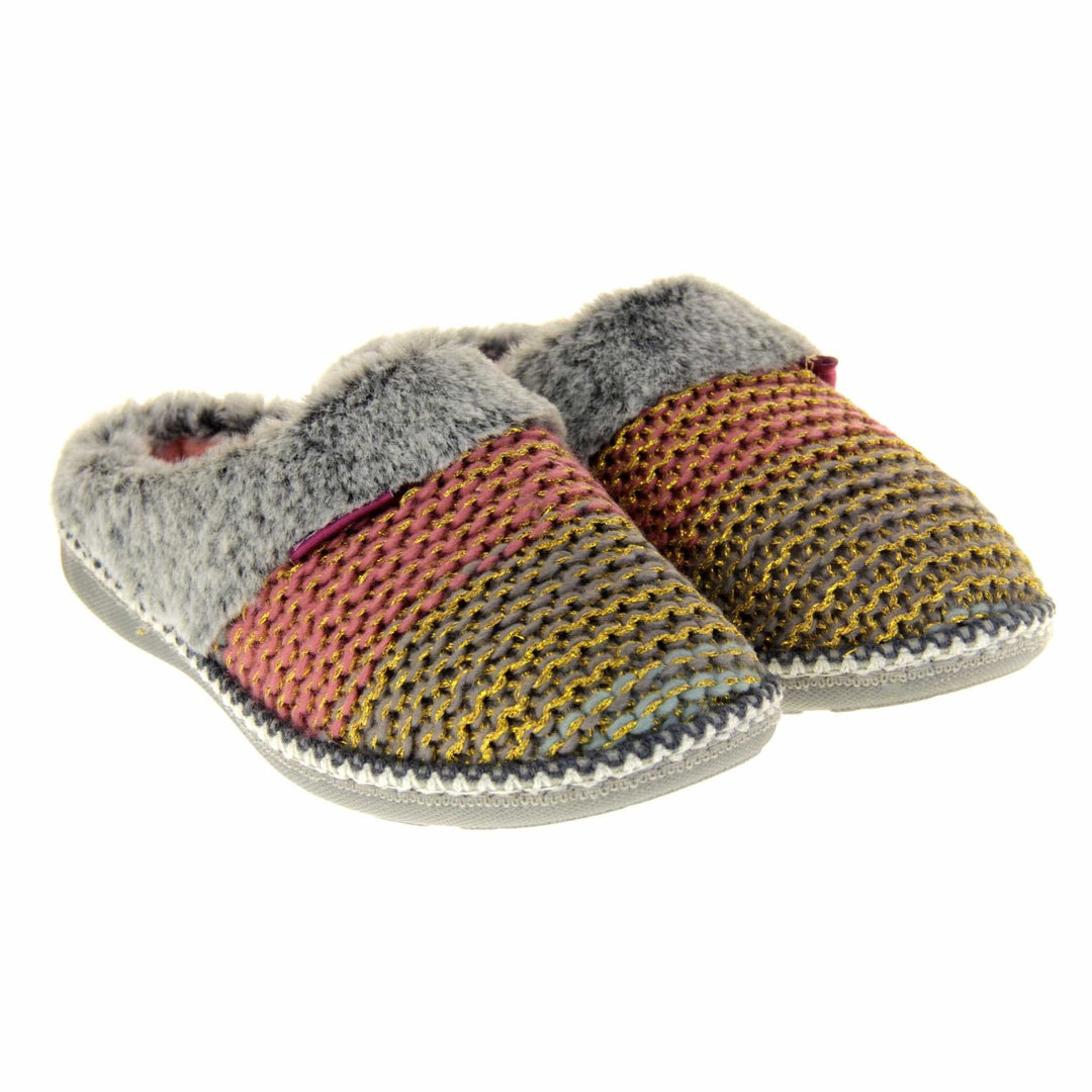 Womens knit slippers. Mule style slippers with pink and blue knit uppers with metallic gold thread running through. Grey faux fur collar. Pink textile lining and firm grey outsole with grip on the bottom. Both feet together at an angle.