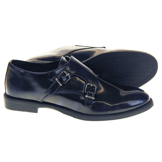 Womens leather brogues. Loafer shoes in a Brogue style with a dark blue faux leather upper. Faux leather flap over the top fastened with double buckles. Real leather lining. Black sole with a slight heel. Both feet from a side profile with the left foot on its side behind the the right foot to show the sole.