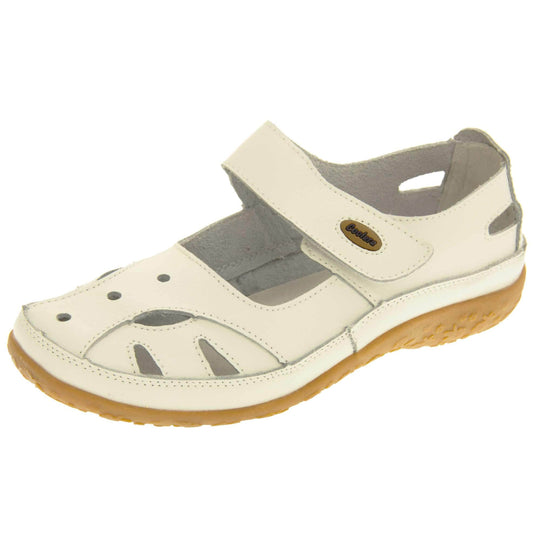 Womens leather shoes. Mary Jane style shoes. White leather uppers with white stitching detail. White touch fasten strap over the foot with brown oval, where it fastens, with Coolers logo in the centre. Cut outs in the middle, edges and heel of the shoes. Brown synthetic soles with flower design grips. Left foot at an angle.