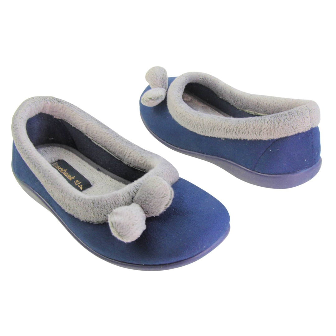 Womens navy slippers. Womens ballerina style slippers with navy blue velour uppers. Grey, plush textile collar and two pom poms to the front of the shoe. Matching textile lining. Firm navy sole. Both feet at an angle facing top to tail.