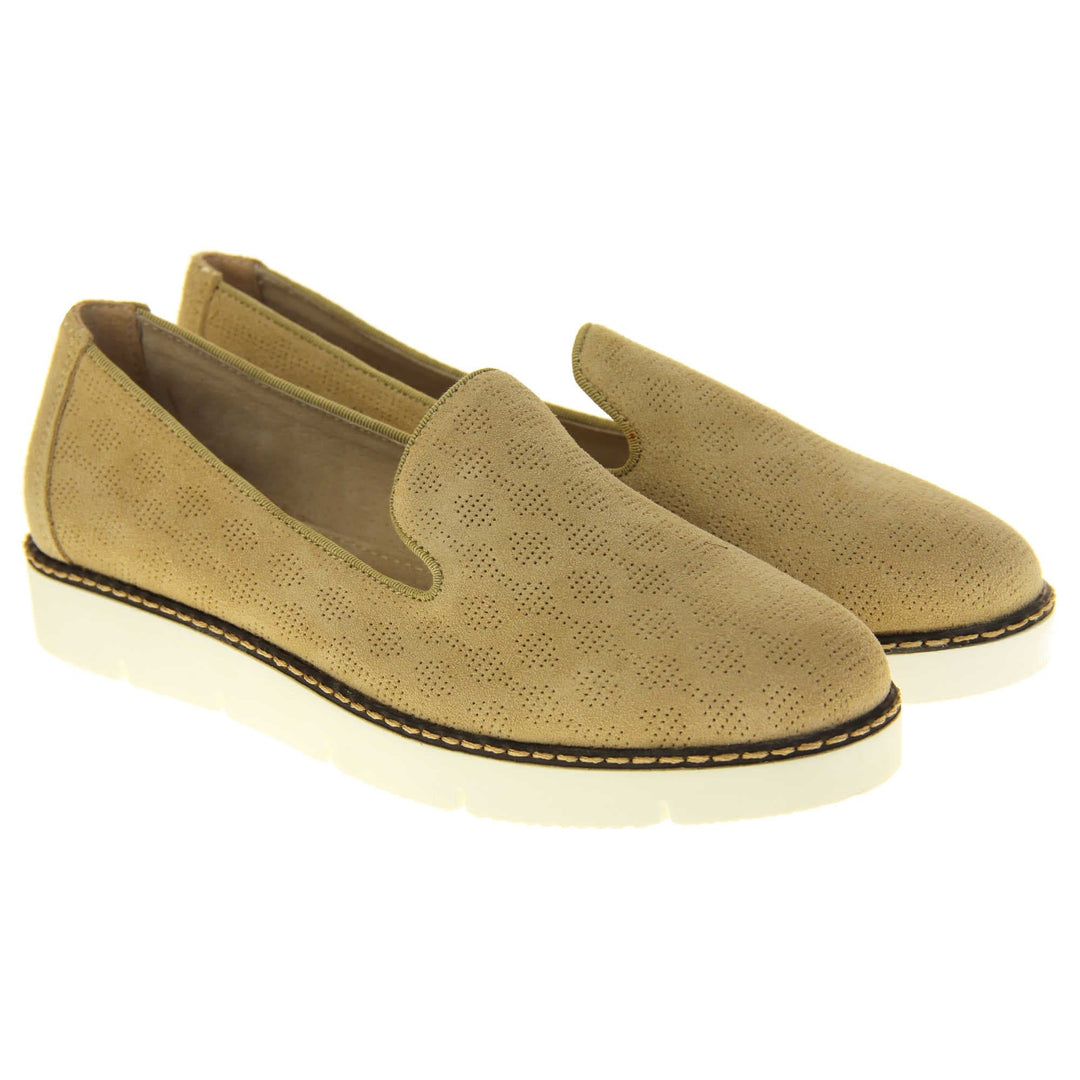 Womens platform loafers. Loafer style shoes with a beige faux-suede upper with pin size dot cut-outs. Plain beige strip over the heel for added support. White flat chunky platform outsole with black rim along the top and beige stitching detail. Cream leather lining. Both feet together at a slight angle.