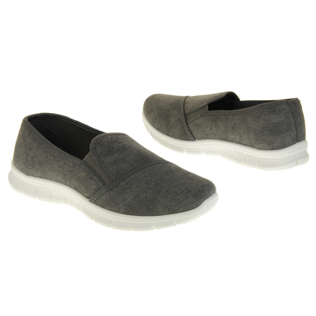 Women's plimsolls grey. Slip on plimsoll style shoes with a grey canvas upper. Grey elasticated gusset. Chunky white sole. Both feet at an angle facing top to tail. 