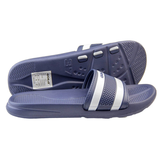Womens pool sliders. Dark blue synthetic over foot strap with two white stripes in between blue ones. Blue Gola branding in the centre of the top white stripe. Dark blue outsole with moulded footbed. Light studs and grip to the base to help prevent slipping. Both feet from a side profile with left foot on its side behind the right to show the sole.