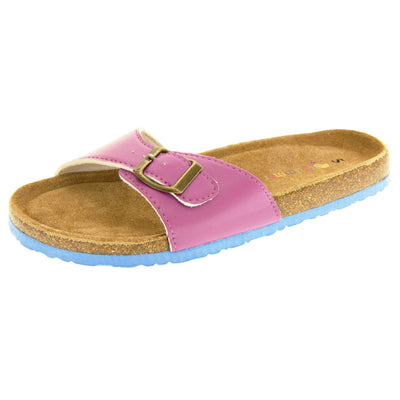 Womens purple sandals. Purple faux leather strap with gold buckle. Soft tan faux suede footbed with cork effect outsole and blue sole. Left foot at an angle.