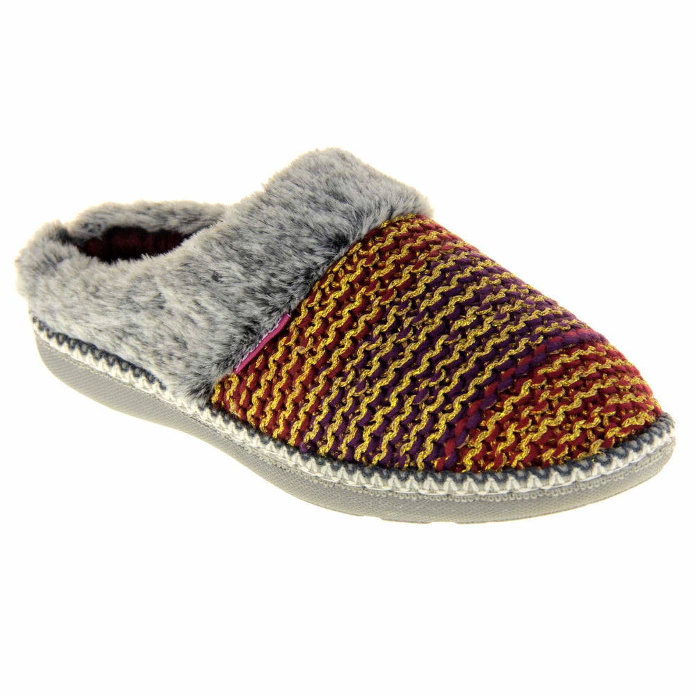 Womens purple slippers. Mule style slippers with purple and red knit uppers with metallic gold thread running through. Grey faux fur collar. Red textile lining and firm grey outsole with grip on the bottom. Right foot at an angle.
