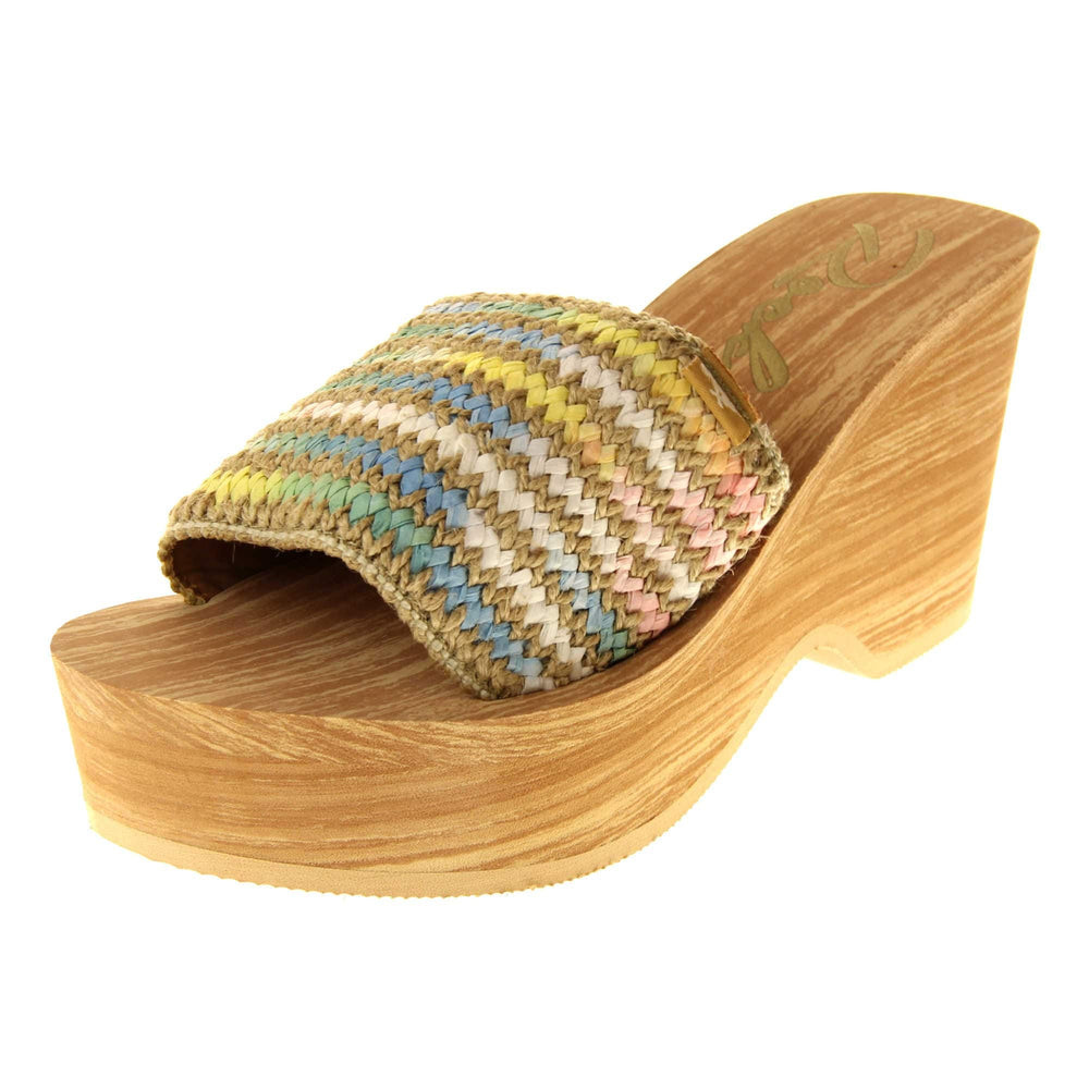 Womens Rocket Dog Wedge Sandals - Light brown wood-effect foam wedge heels with slider / mary jane strap over in a pastel rainbow zig zag design with a hessian weave in-between rows. Left foot at an angle.