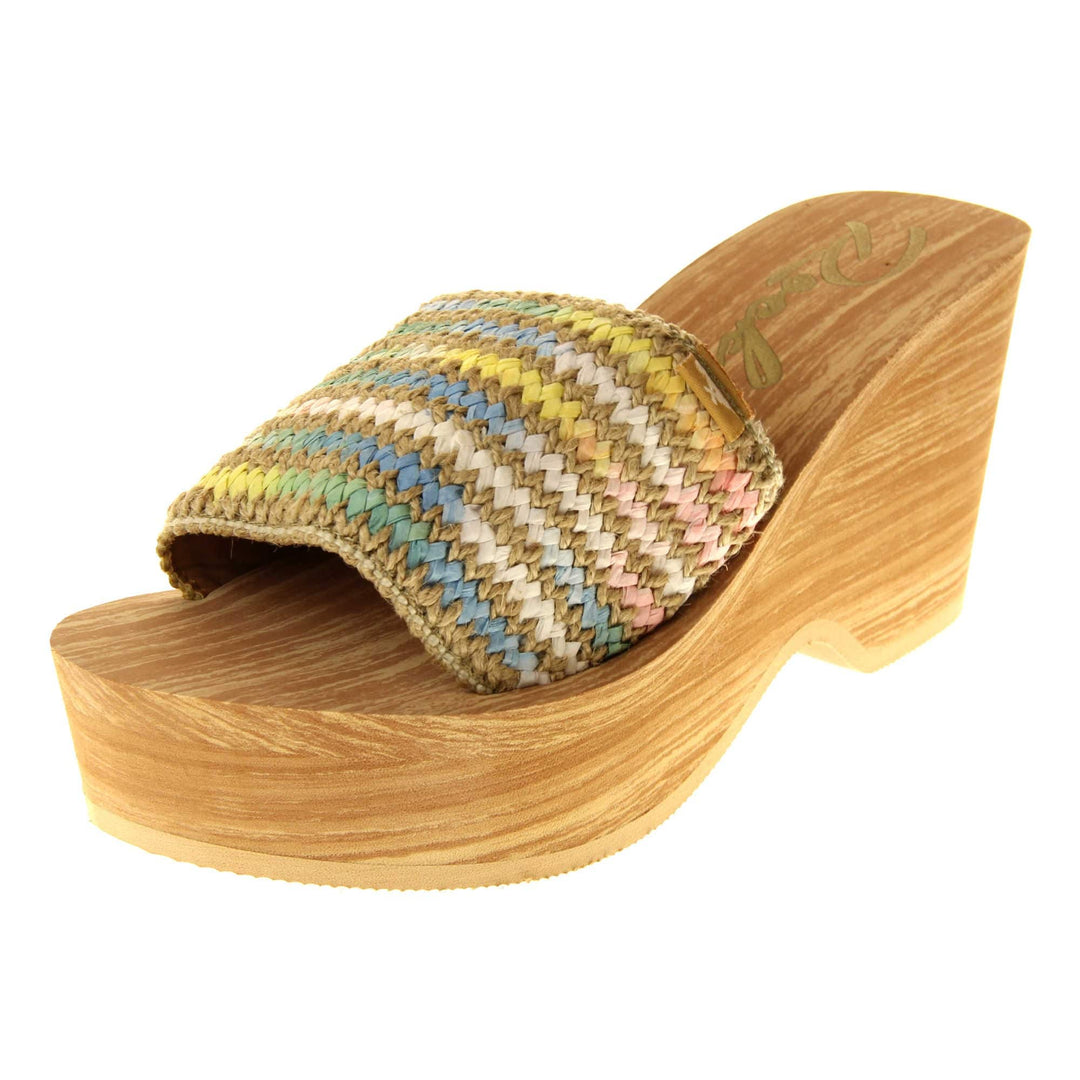 Womens Rocket Dog Wedge Sandals - Light brown wood-effect foam wedge heels with slider / mary jane strap over in a pastel rainbow zig zag design with a hessian weave in-between rows. Left foot at an angle.