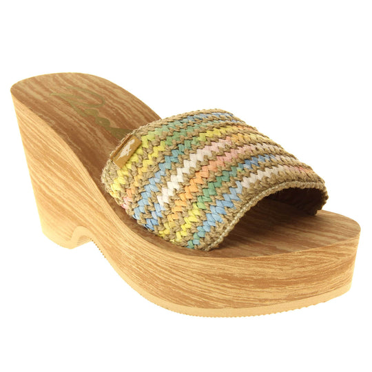 Womens Rocket Dog Wedge Sandals - Light brown wood-effect foam wedge heels with slider / mary jane strap over in a pastel rainbow zig zag design with a hessian weave in-between rows. Right foot at an angle.
