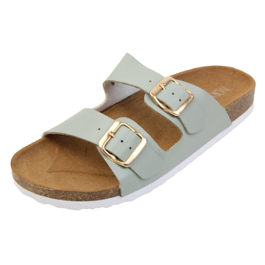 Womens sage sandals. Womens dual strap slip on sandals. With a sage green synthetic leather upper with a gold buckle on each strap. Brown faux suede insole with a moulded footbed. Cork effect outsole with white base with grip to the bottom. Left foot at an angle.