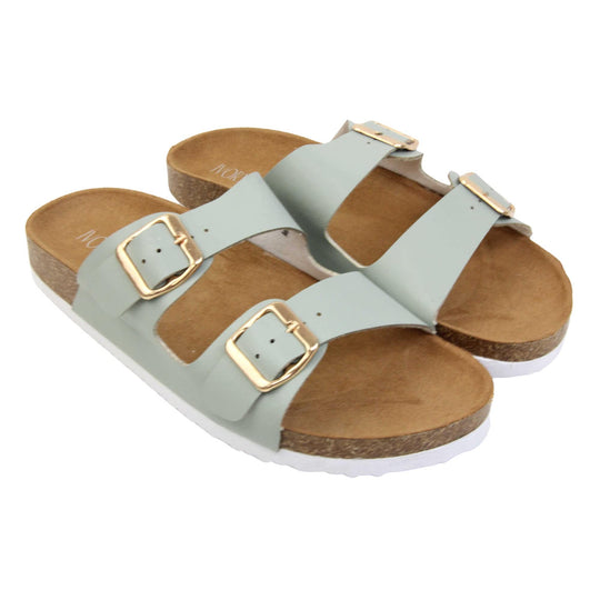 Womens sage sandals. Womens dual strap slip on sandals. With a sage green synthetic leather upper with a gold buckle on each strap. Brown faux suede insole with a moulded footbed. Cork effect outsole with white base with grip to the bottom. Both feet together at a slight angle.