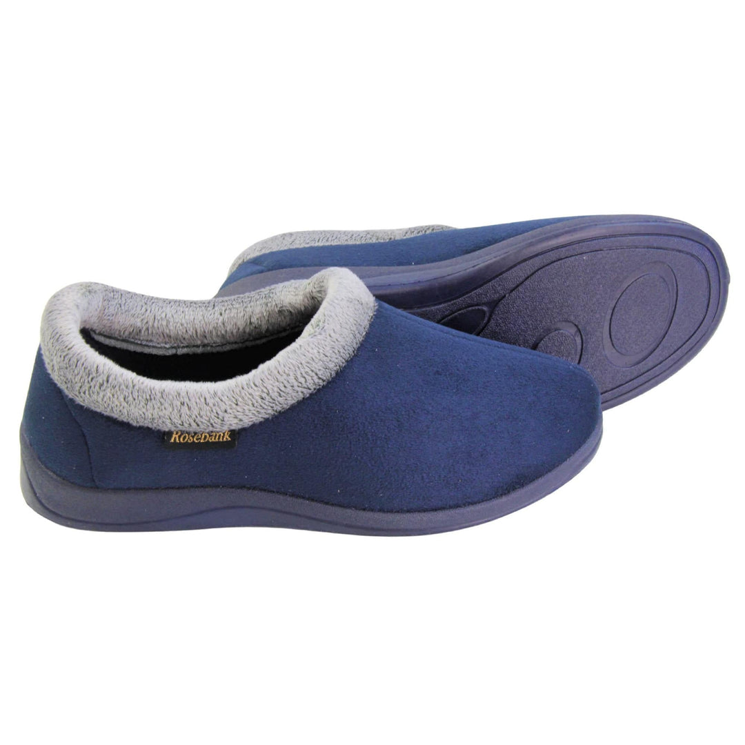 Womens slippers with back. Womens low top bootie style slippers with navy blue velour uppers. Grey plush textile collar. Matching textile lining. Firm navy sole. Both feet from a side profile with the left foot on its side behind the the right foot to show the sole.