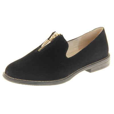 Womens smart loafers. Loafer style shoes with black faux suede uppers. Short gold zip detail to the top of the shoe. Gold stud detail around the rim of the sole. Black sole with very small heel and beige leather lining. Left foot at an angle.