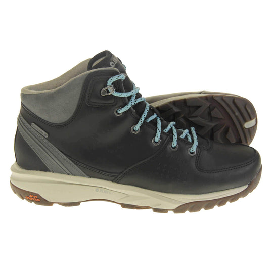 Womens walking boots. Black leather walking boots with grey soles of the side, black soles on the bottom. Deep grip on the base. Pale blue laces to the front with Hi-Tec branding in grey on the tongue. Grey velour padded collar for ankles. Both feet from side profile with left foot on its side to show the sole.