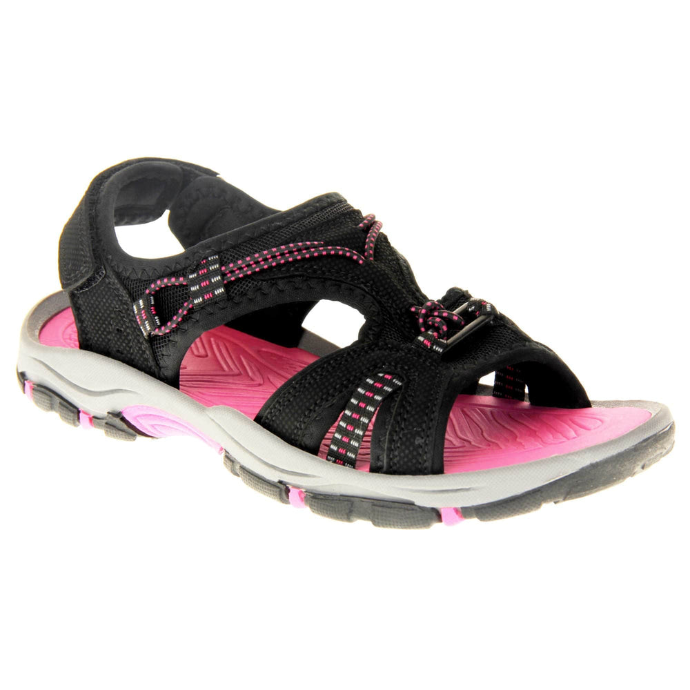 Womens walking sandals - Black suede effect upper with hot pink elasticated strap detailing, and a hook and loop touch fastening backstrap to the ankle. Fuchsia pink comfy insole with grey, black and fuschia flexible outsole with good grips. Right foot at an angle.