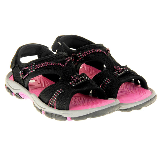 Womens walking sandals - Black suede effect upper with hot pink elasticated strap detailing, and a hook and loop touch fastening backstrap to the ankle. Fuchsia pink comfy insole with grey, black and fuschia flexible outsole with good grips. Both feet together at an angle.