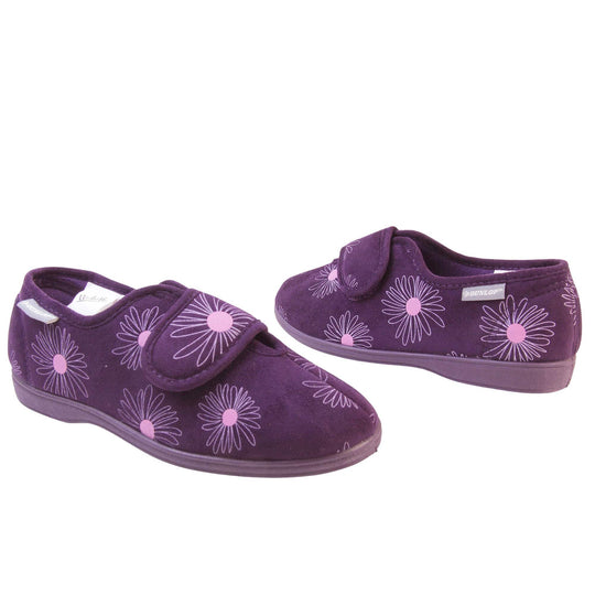 Womens washable slippers. Ladies full back slipper. Purple upper with white daisy design and bright pink for the middle of the flowers. Touch fasten strap over the top of the foot to adjust the fit. Matching purple textile lining and firm purple sole. Both feet at an angle, facing top to tail.