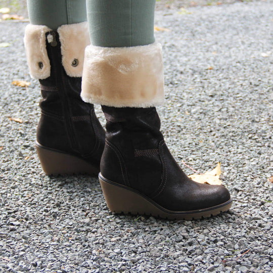 Womens wedge heel boots - brown suede effect upper with chunky wedge heel, full inner zip, faux fur cuff and brown stitching. Model shot on gravel.